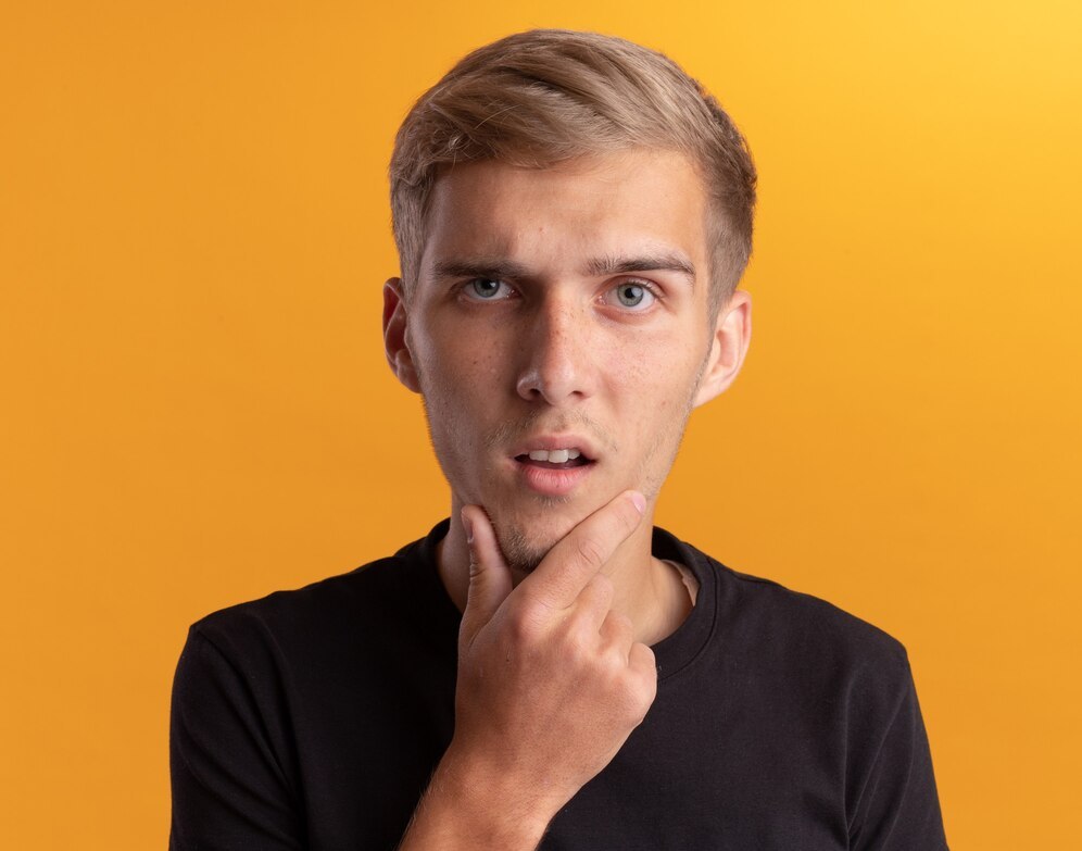 A puzzled young man, hand on chin